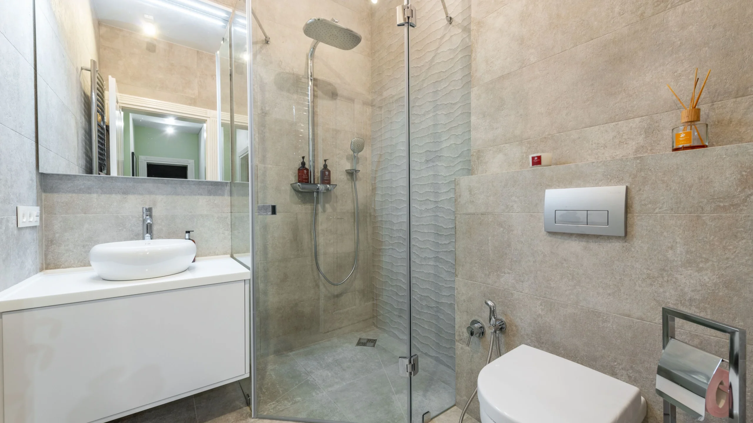 Contemporary bathroom with a wall hung vanity, frameless glass shower screen and large format wall tiles