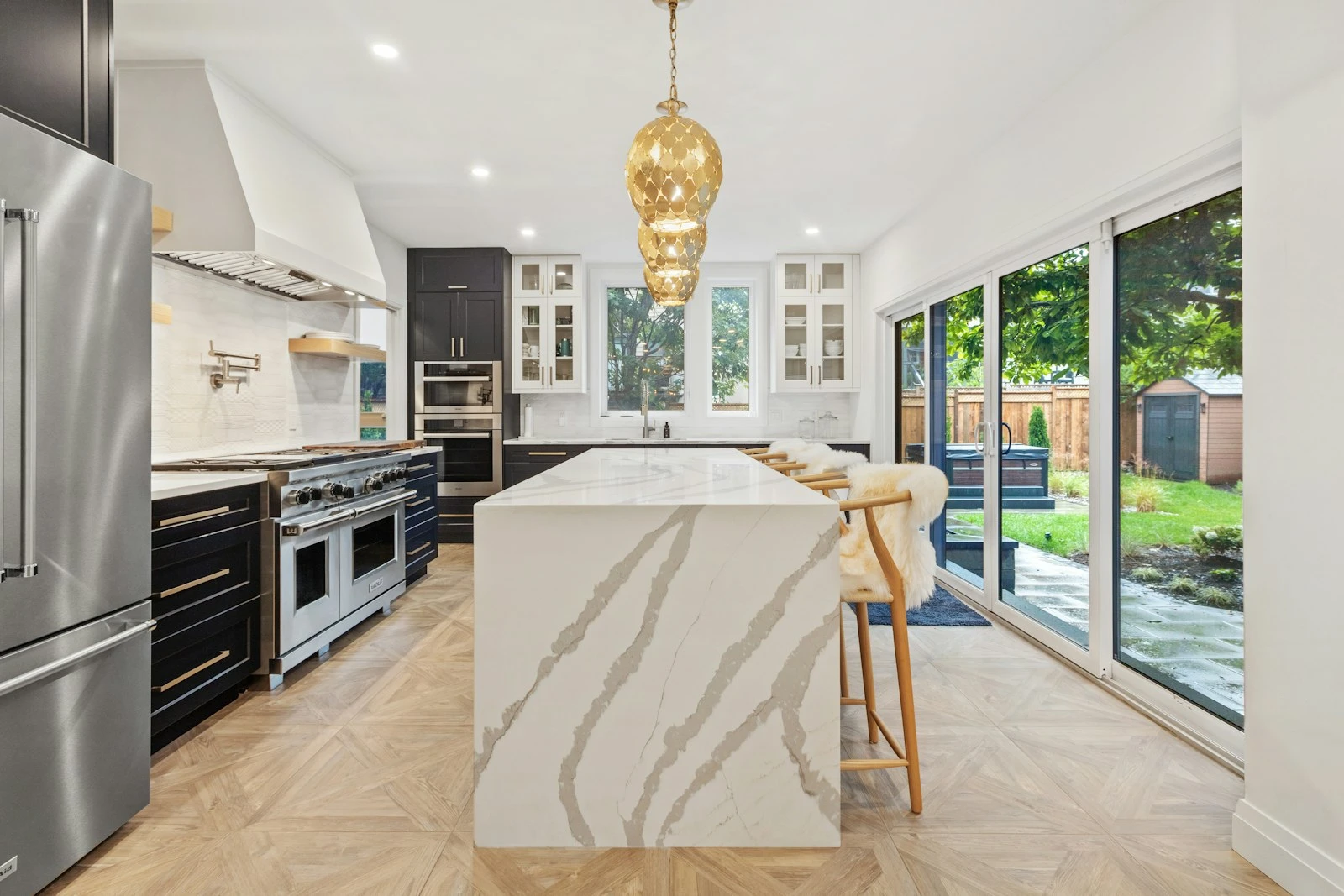 Kitchen beneath a sculptural pendant with garden outlook