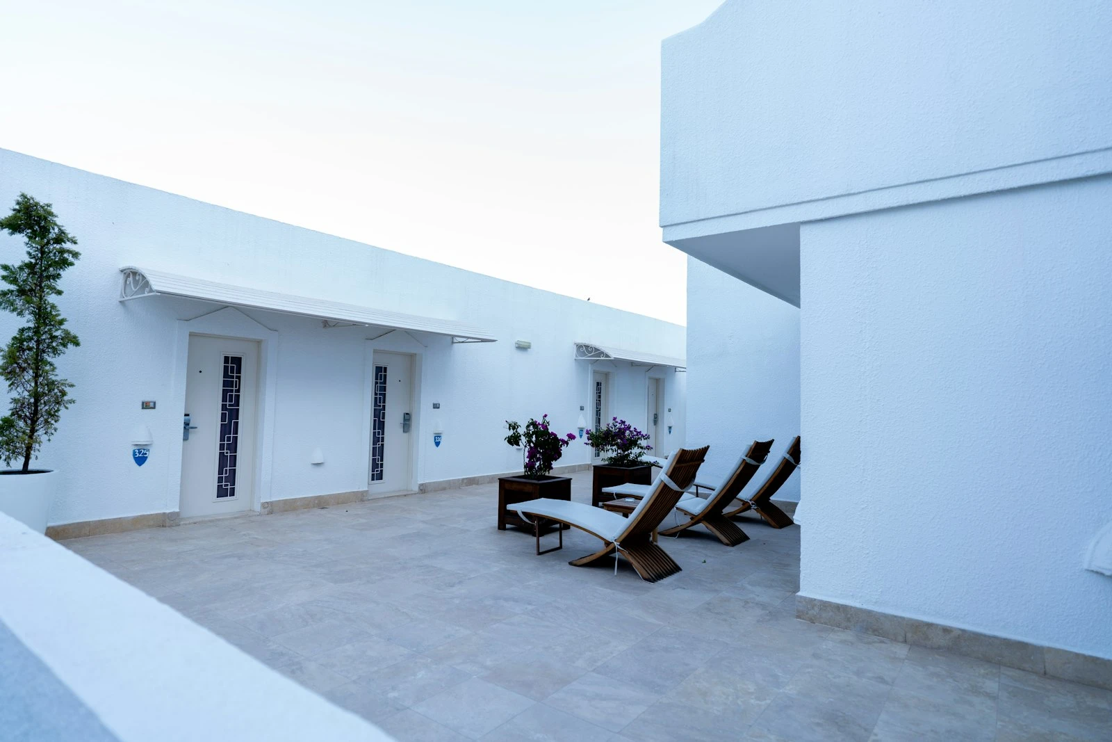 Minimal terrace with loungers beside a rendered wall