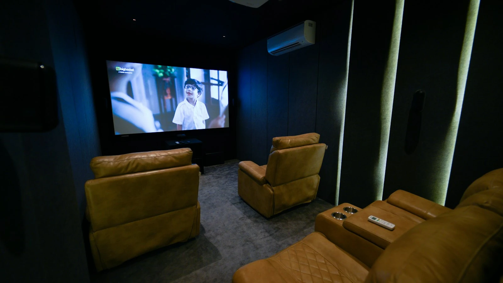 Dark dedicated cinema room with a full width screen