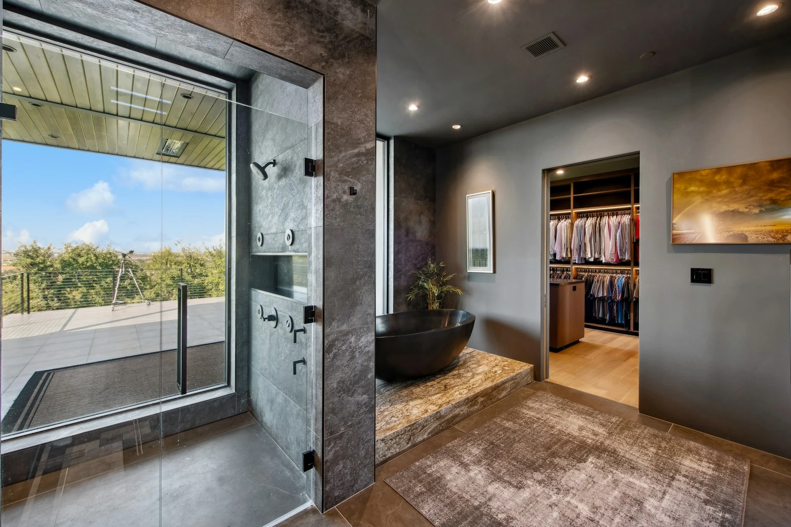 Bathroom opening to a garden through full height glazing