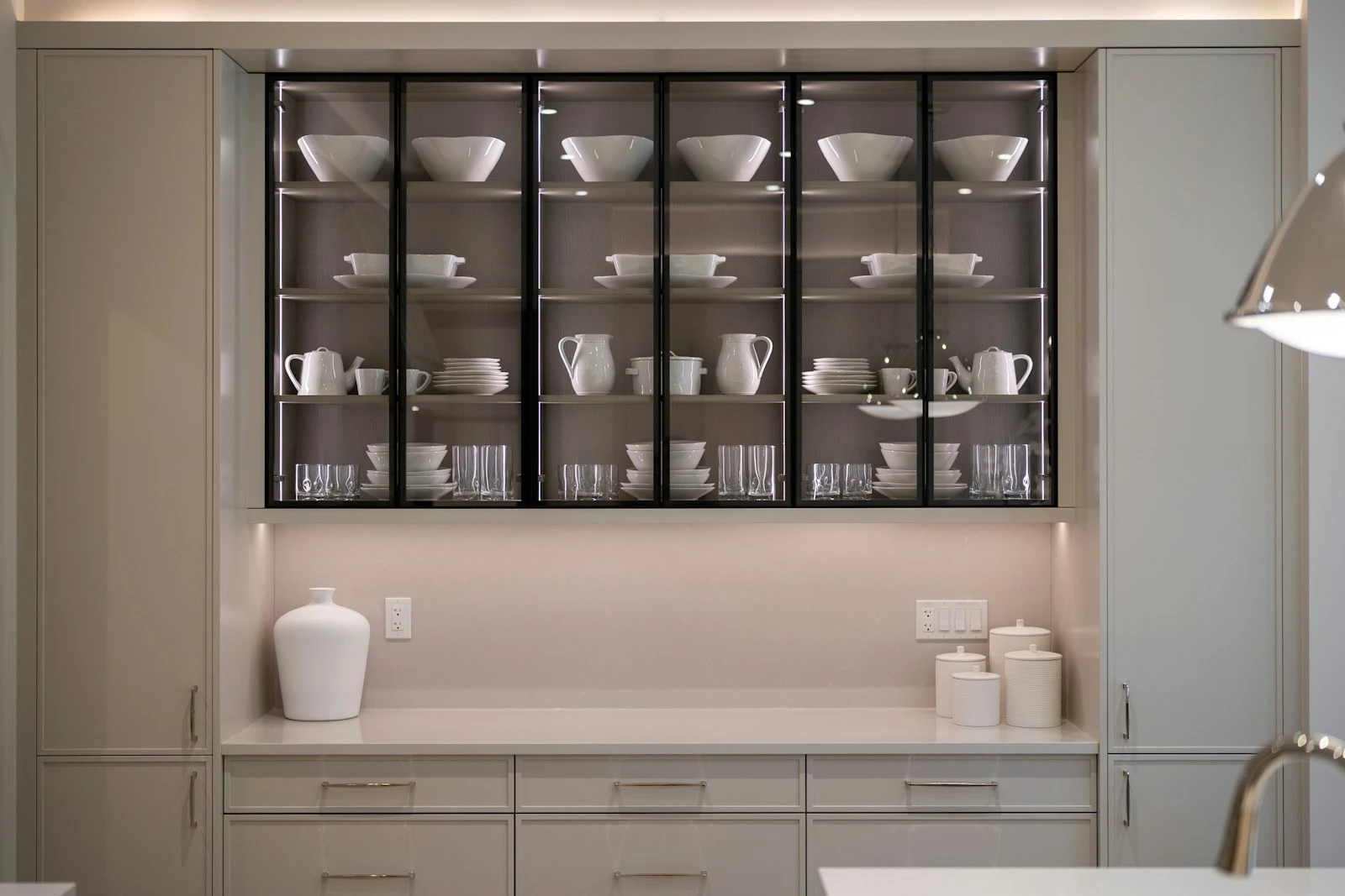Butler's pantry with glazed cabinetry behind the main kitchen