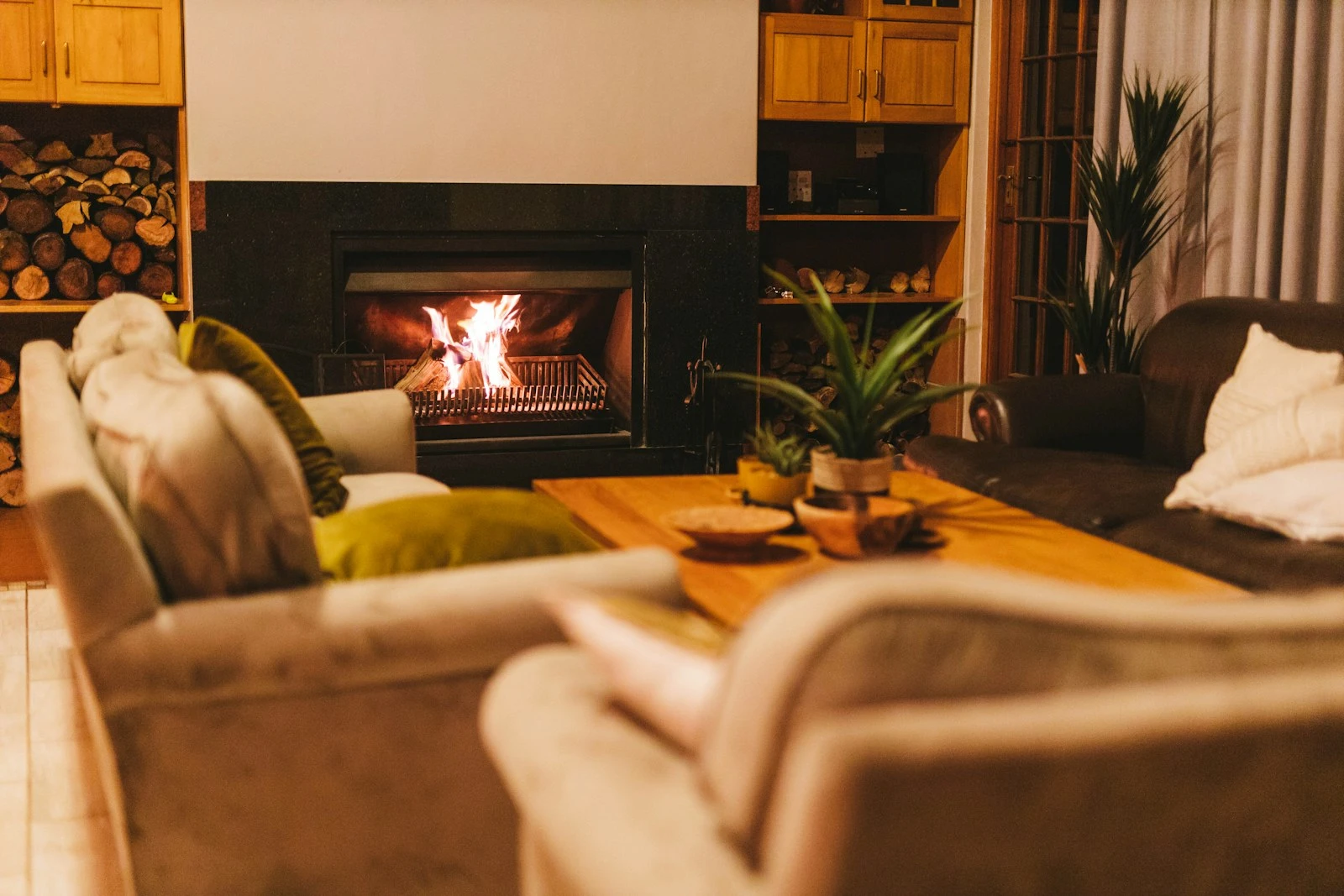 Warm living room with a lit fire and layered textiles