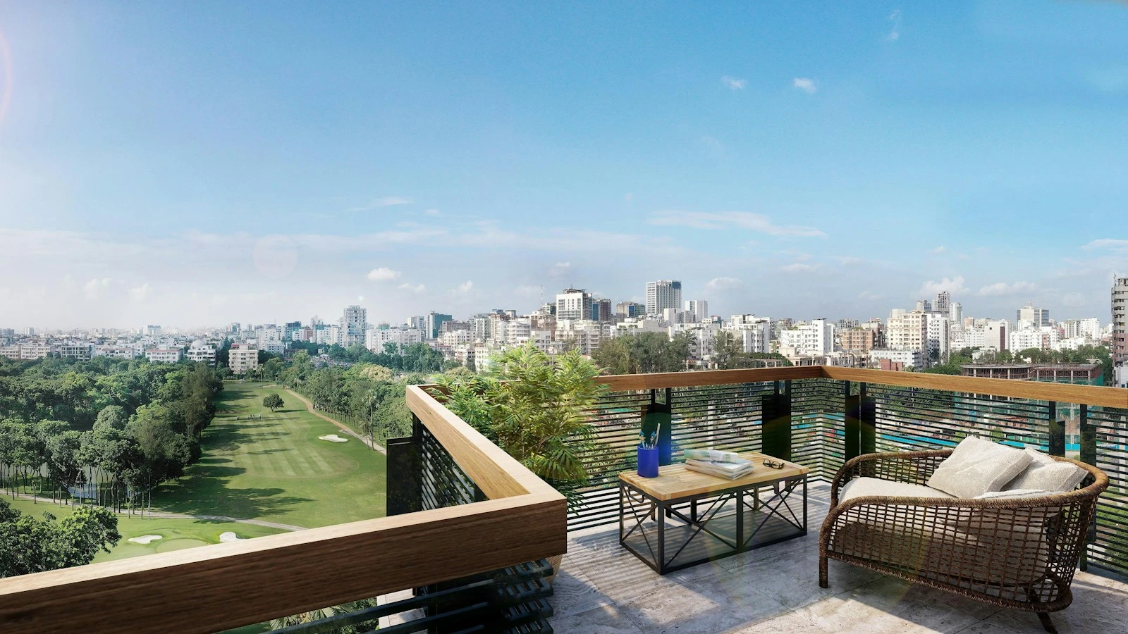 Apartment balcony with outdoor seating overlooking parkland and a city skyline